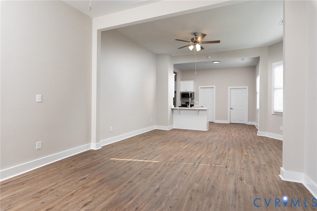 9800 Golf Course Drive Disputanta, VA 23842 - Photo 10 of 19 wooden floor in an empty room with a kitchen