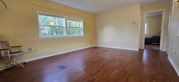 a view of a room with wooden floor and windows