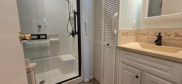 a bathroom with a shower sink and mirror