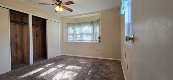 a view of a livingroom with a ceiling fan and window