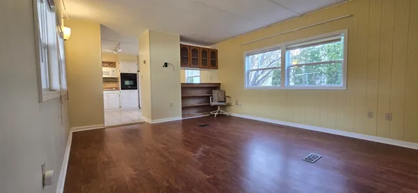 a view of a livingroom with wooden floor and a window