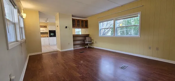 a view of a kitchen with wooden floor and a window
