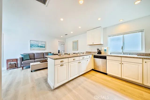 a kitchen with granite countertop white cabinets and white appliances