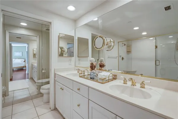 a bathroom with a double vanity sink mirror and toilet