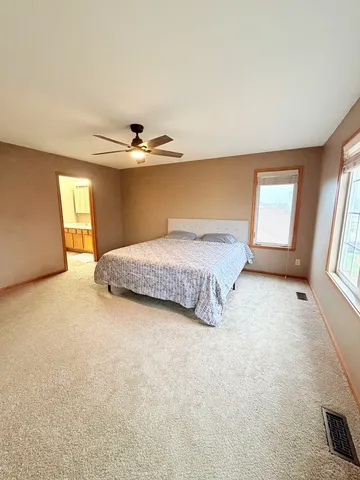 a spacious bedroom with a bed and a window