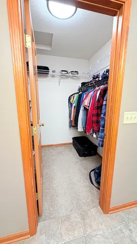a view of walk in closet with clothes and shoes