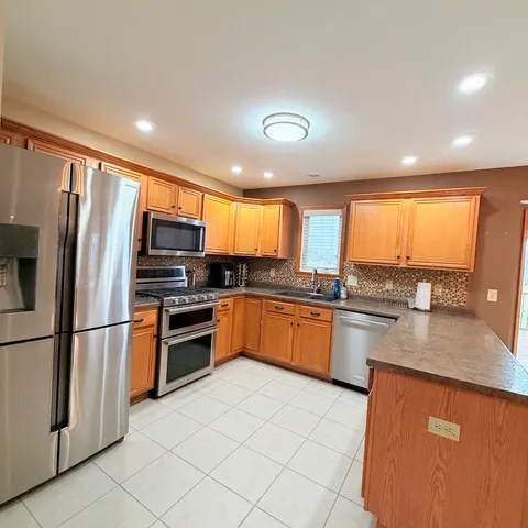 a kitchen with stainless steel appliances granite countertop a refrigerator sink and cabinets