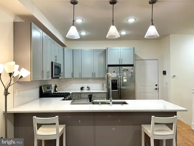 a kitchen with stainless steel appliances granite countertop a sink a stove a refrigerator and cabinets