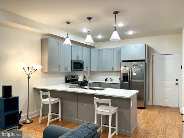 a kitchen with kitchen island granite countertop a sink a counter space appliances and cabinets