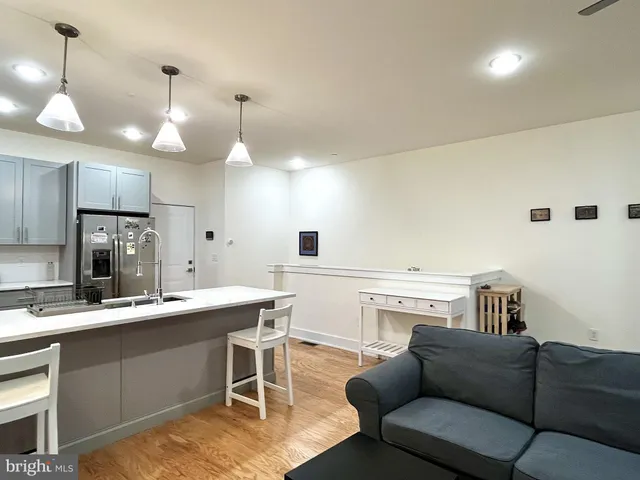 a kitchen with a stove a sink a kitchen island with a dining table and chairs