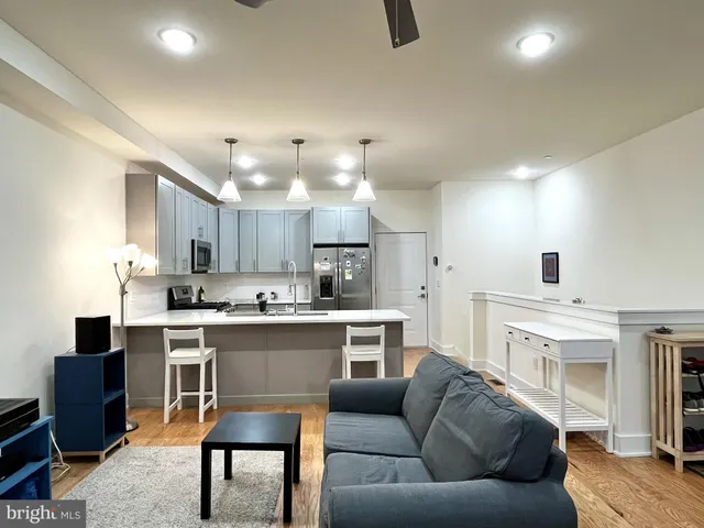 a living room with furniture kitchen view and a fireplace