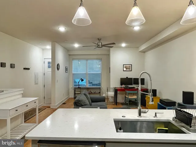 a room with kitchen island a sink and a stove with wooden floor