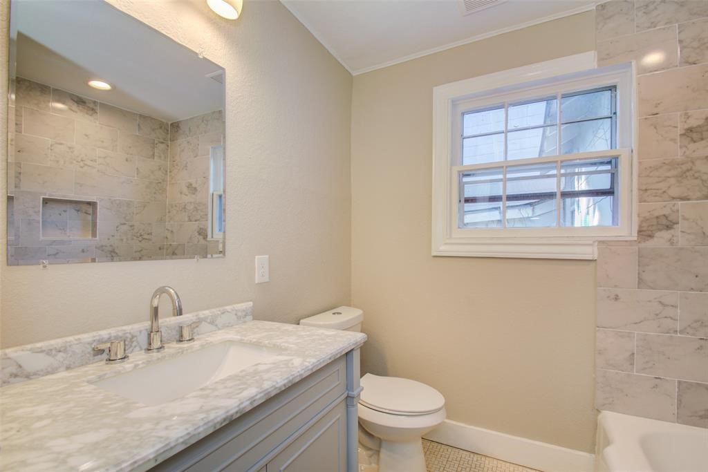 417 Sue Street, Unit A Houston, TX 77009 - Photo 8 of 11 a bathroom with a granite countertop sink a toilet and a mirror