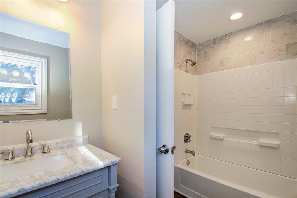 417 Sue Street, Unit A Houston, TX 77009 - Photo 10 of 11 a bathroom with a granite countertop sink mirror toilet and bathtub