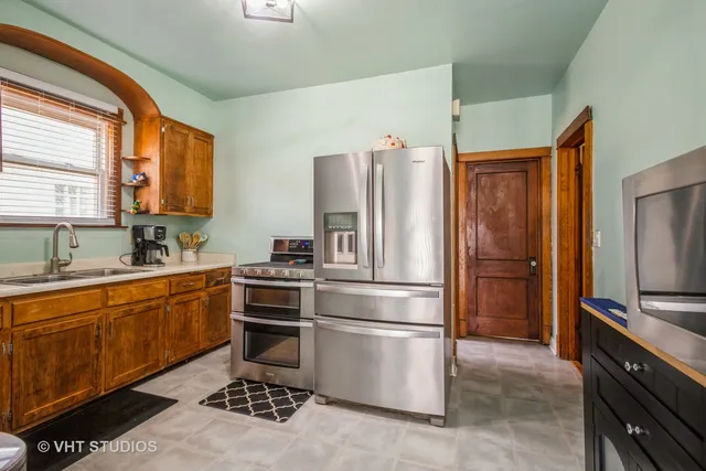 a kitchen with granite countertop stainless steel appliances a refrigerator stove top oven and sink