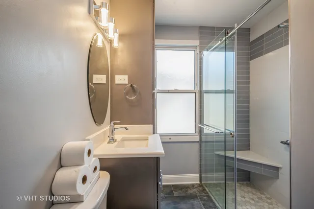 a bathroom with a sink mirror and a shower