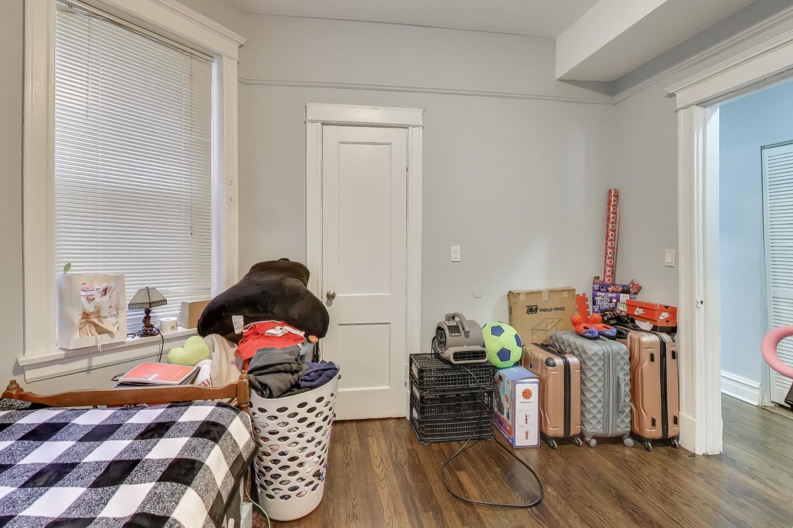 6149 South Rhodes Avenue Chicago, IL 60637 - Photo 14 of 50 a bedroom with a bed and wooden floor