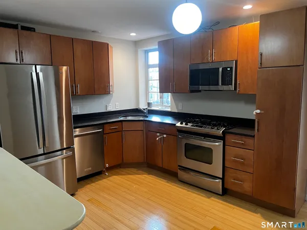 a kitchen with stainless steel appliances granite countertop a refrigerator stove and microwave