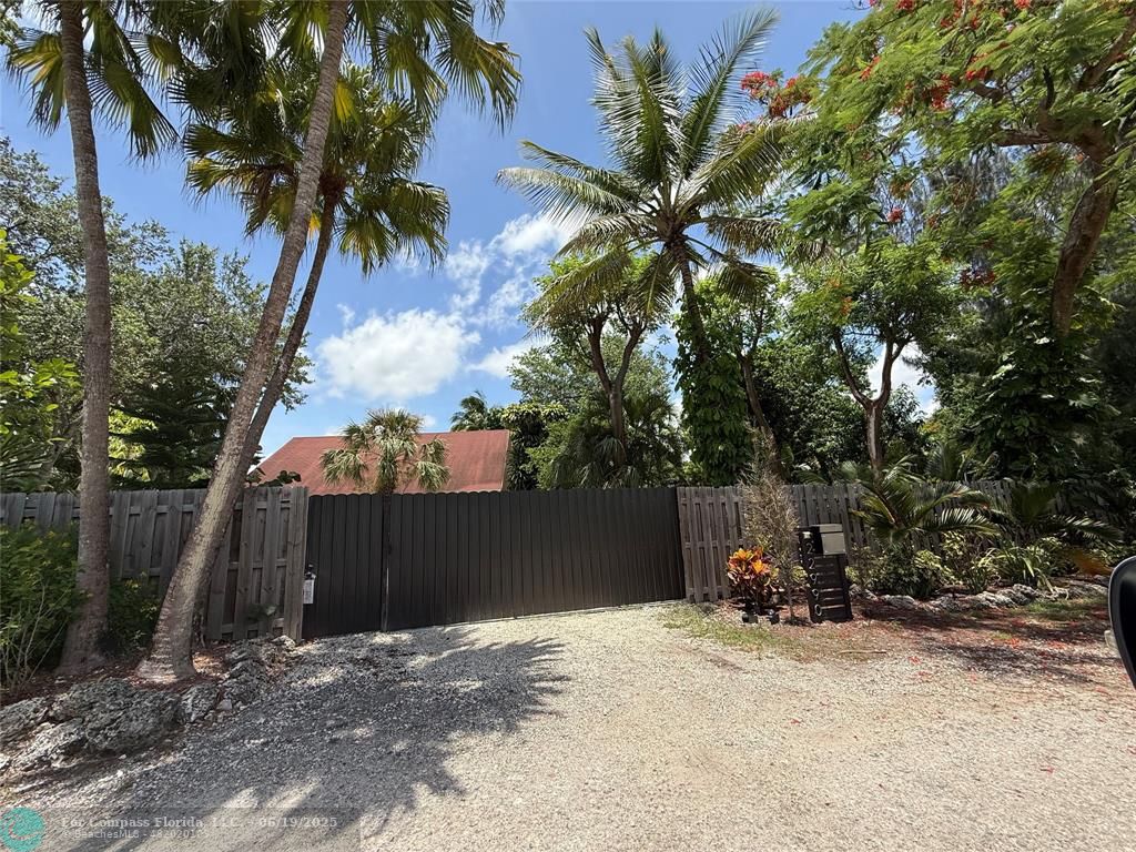 22990 Southwest 156th Avenue Miami, FL 33170 - Photo 3 of 41 a backyard of a house with table and chairs under an umbrella