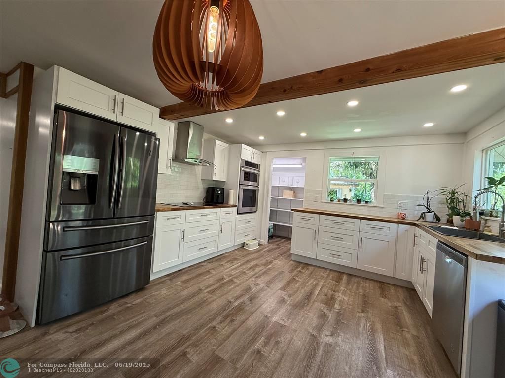 22990 Southwest 156th Avenue Miami, FL 33170 - Photo 6 of 41 a kitchen with stainless steel appliances kitchen island granite countertop a refrigerator and a stove top oven