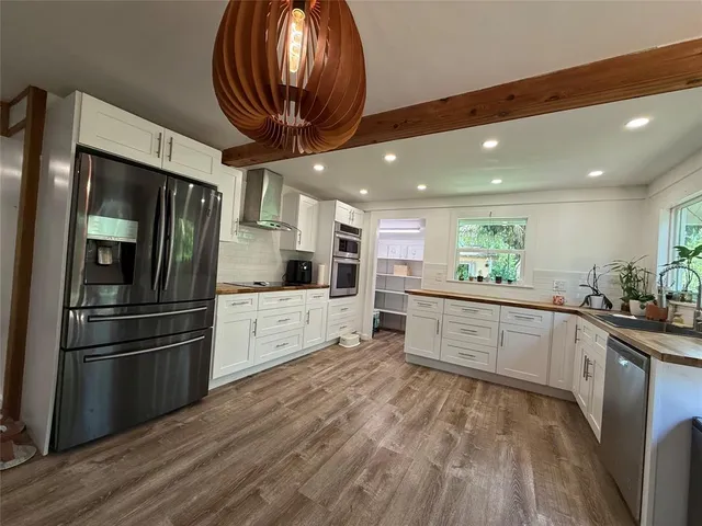 a kitchen with stainless steel appliances kitchen island granite countertop a refrigerator and a stove top oven