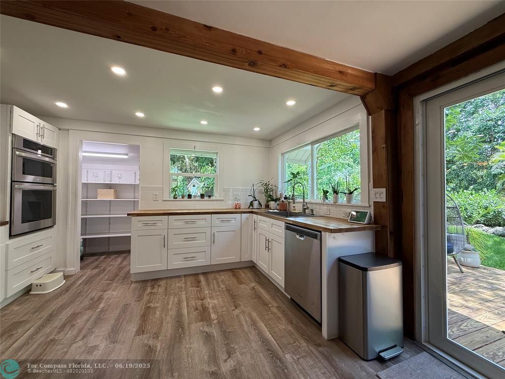 22990 Southwest 156th Avenue Miami, FL 33170 - Photo 7 of 41 a kitchen with stainless steel appliances granite countertop white cabinets and window