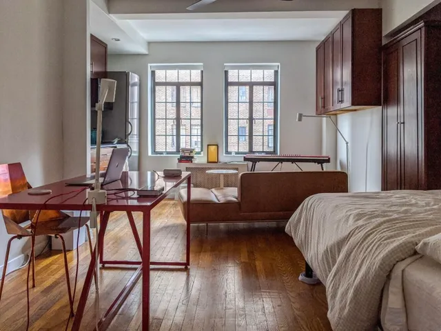 a bedroom with a bed and a large window