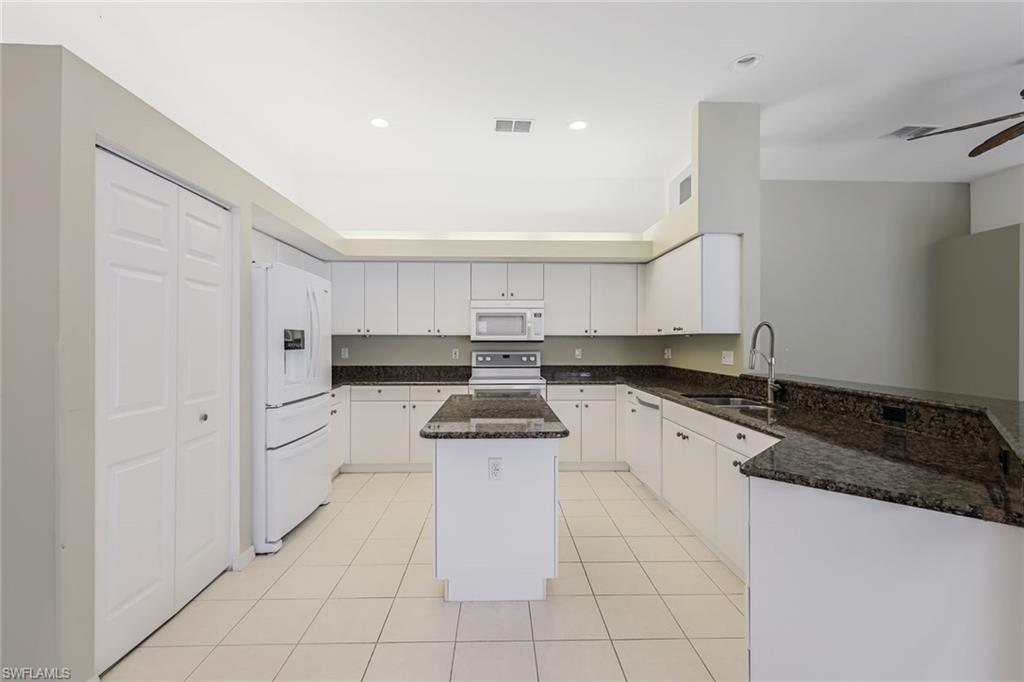 10221 Cape Roman Road, Unit 102 Estero, FL 34135 - Photo 10 of 49 Island Kitchen with Pantry & Breakfast Bar