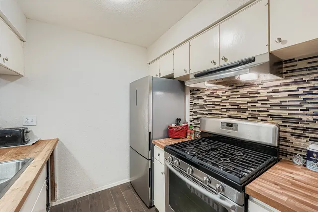 a kitchen with wooden cabinets and a stove top oven