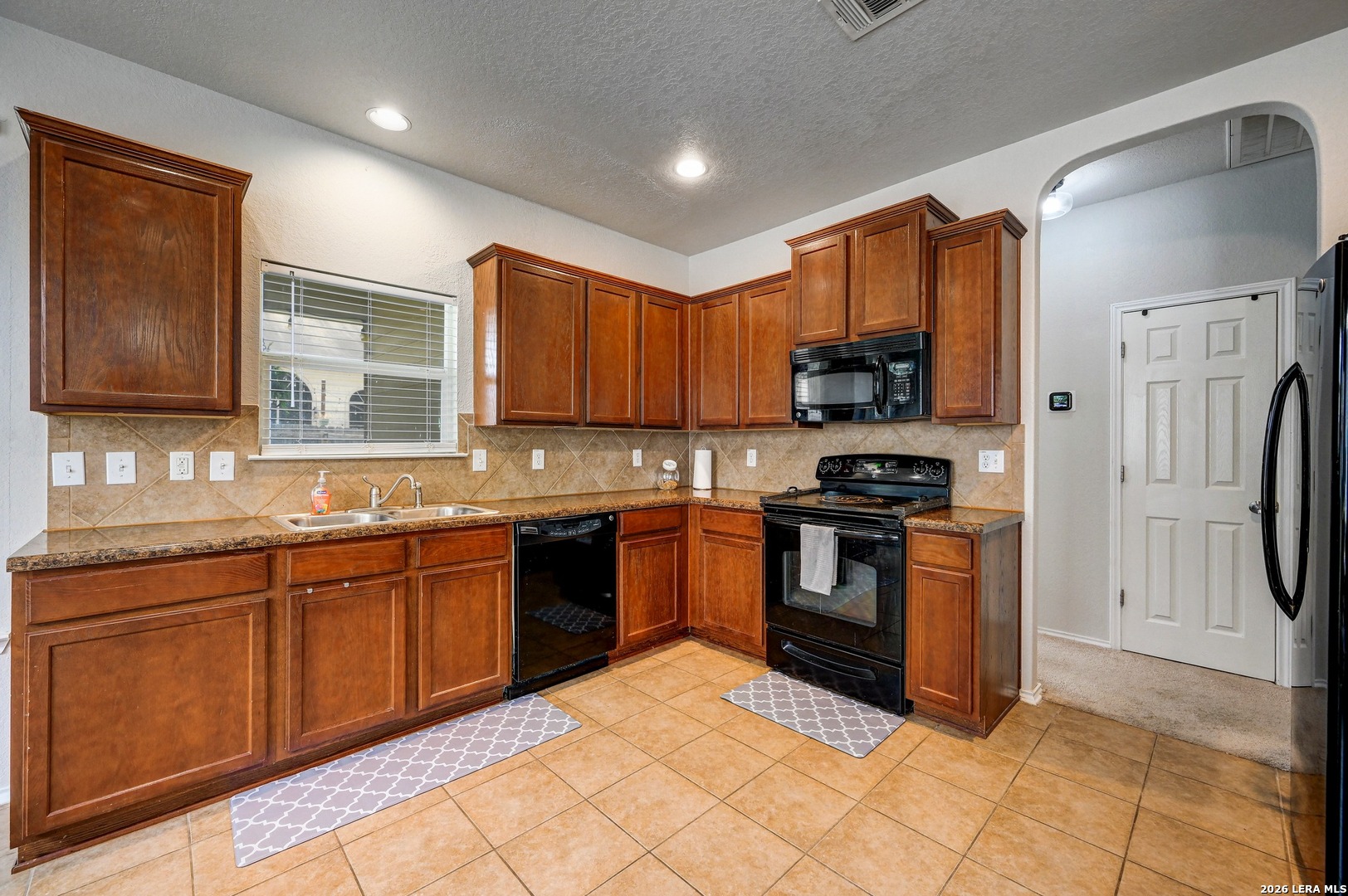 720 Hollow Ridge Schertz, TX 78108 - Photo 12 of 27 a kitchen with stainless steel appliances granite countertop a stove top oven a sink and dishwasher a refrigerator with wooden cabinets