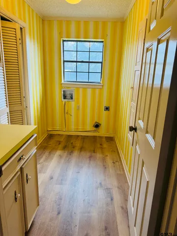 a view of a room with wooden floor and door