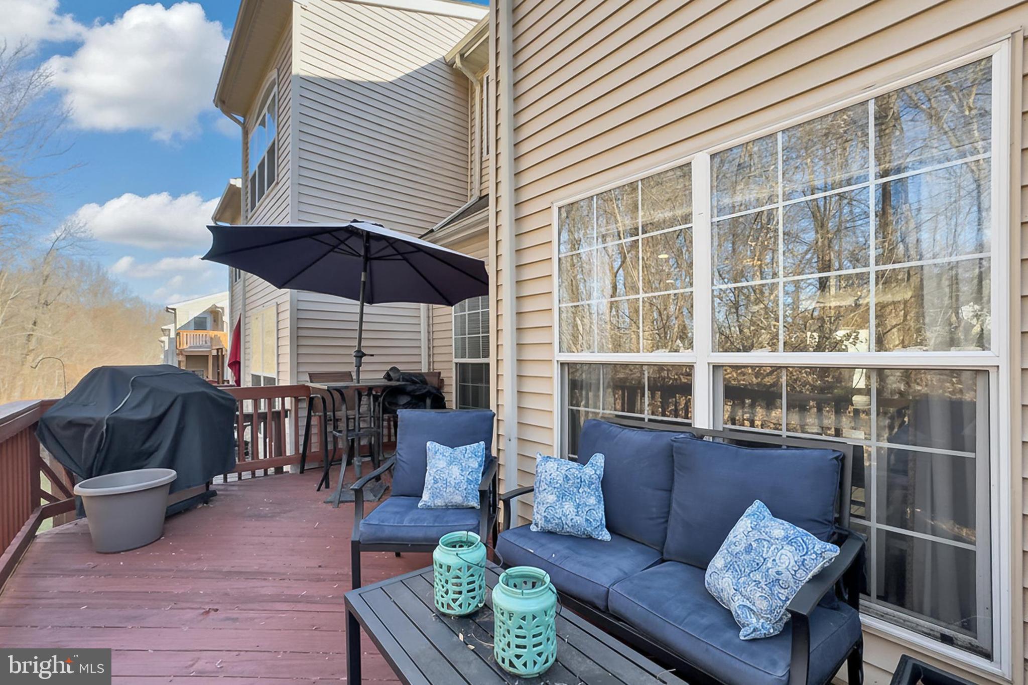 8445 Carmela Circle Springfield, VA 22153 - Photo 25 of 53 a view of a patio with couches table and chairs under an umbrella