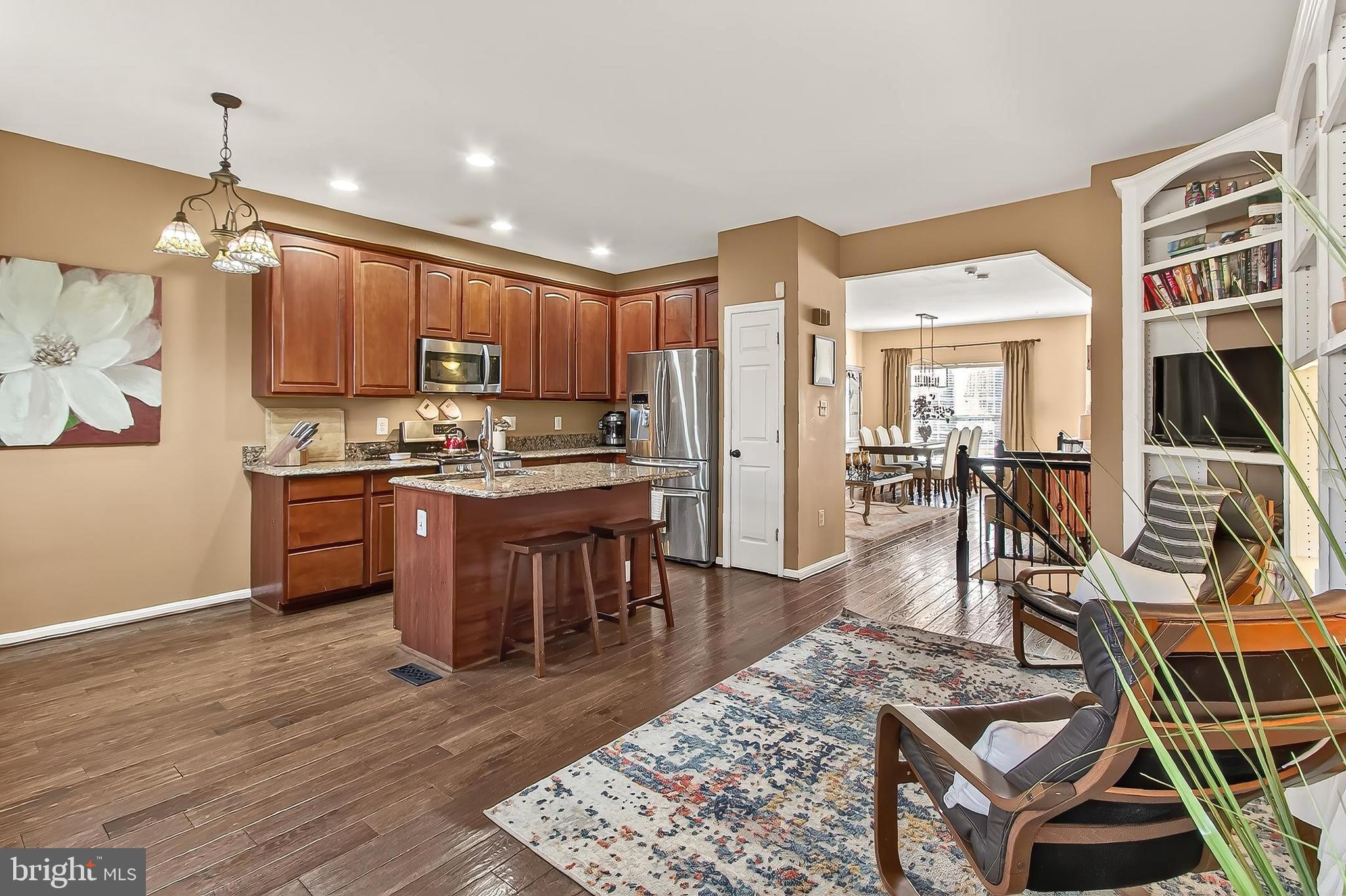 8445 Carmela Circle Springfield, VA 22153 - Photo 33 of 53 a open kitchen with stainless steel appliances granite countertop a stove refrigerator and a dining table with wooden floor