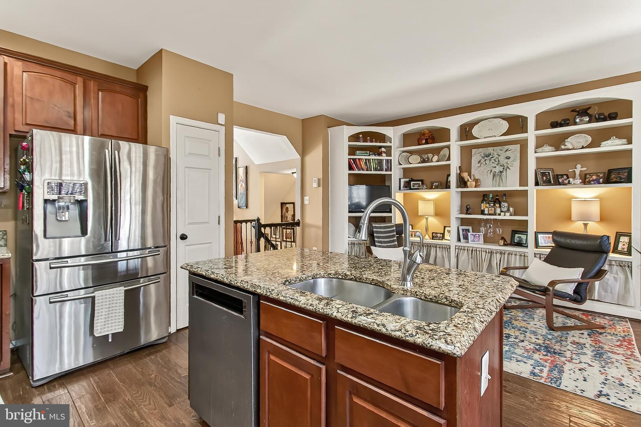 8445 Carmela Circle Springfield, VA 22153 - Photo 34 of 53 a kitchen with stainless steel appliances granite countertop a refrigerator a stove and a sink with wooden floors