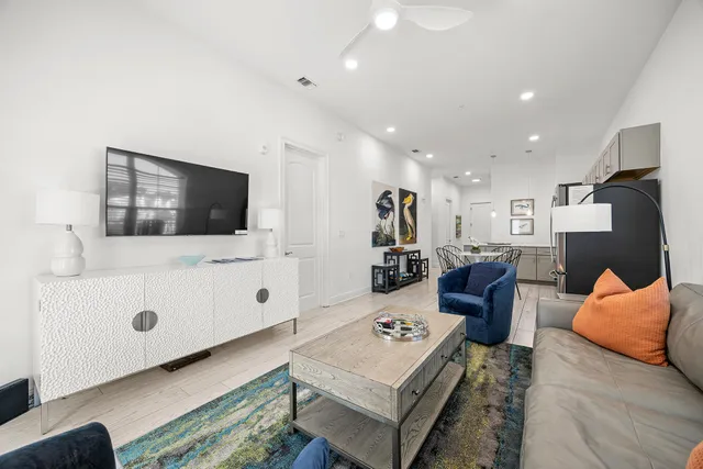 a kitchen with stainless steel appliances a dining table chairs and a refrigerator