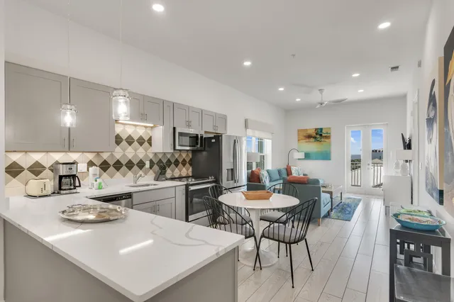 a kitchen with stainless steel appliances granite countertop a dining table and chairs