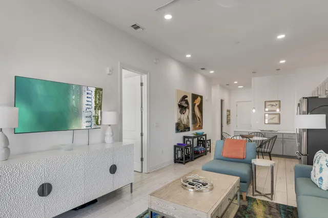 a kitchen with stainless steel appliances a dining table chairs refrigerator and microwave