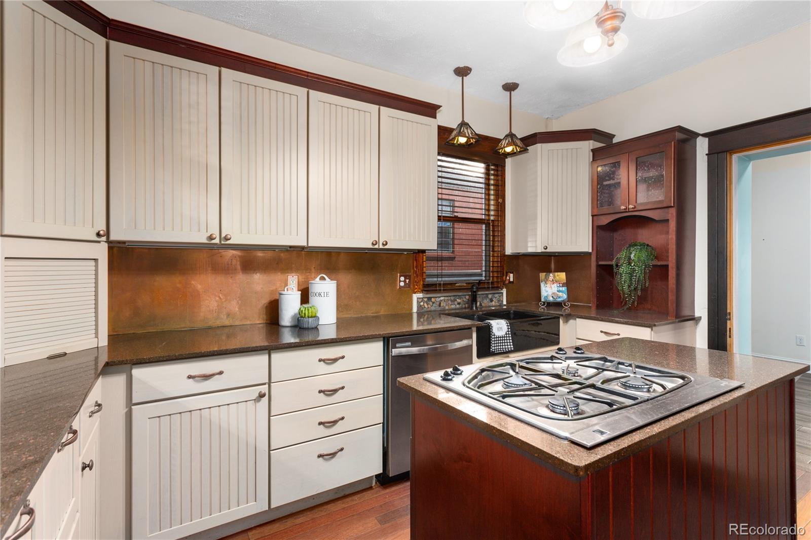 3777 Stuart Street Denver, CO 80212 - Photo 14 of 40 a kitchen with kitchen island granite countertop a sink stove and cabinets