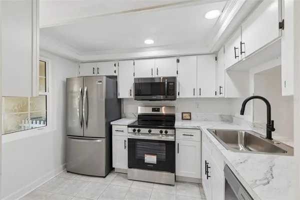 a kitchen with stainless steel appliances granite countertop a refrigerator stove and sink