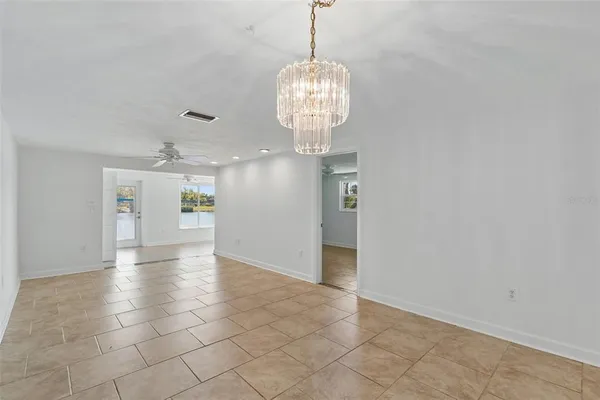 a view of a hallway with chandelier and glass door