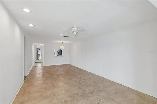 en empty room with a window and a ceiling fan