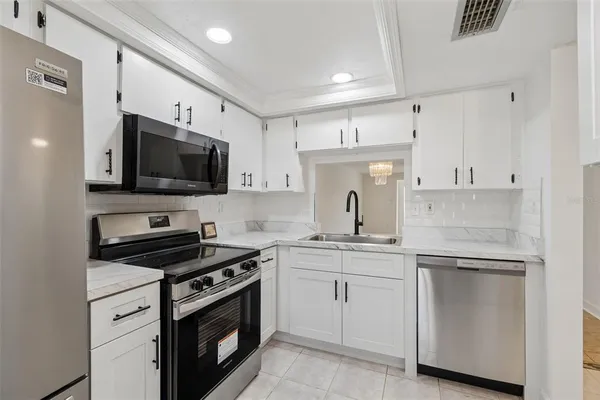 a kitchen with white cabinets stainless steel appliances and sink