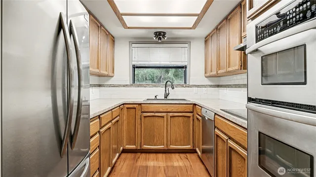 a kitchen with stainless steel appliances a sink and a window