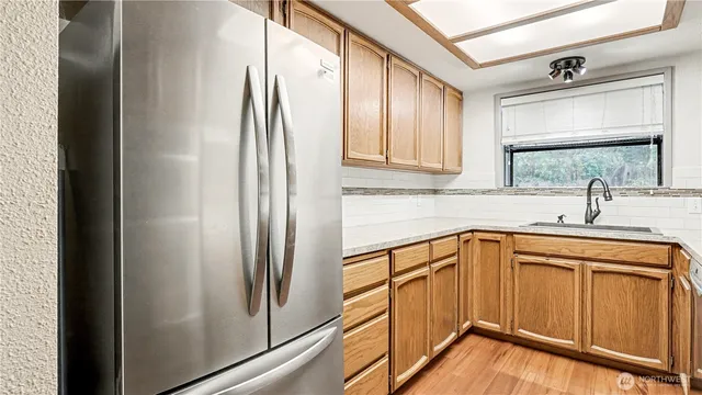 a kitchen with stainless steel appliances granite countertop a refrigerator and a sink