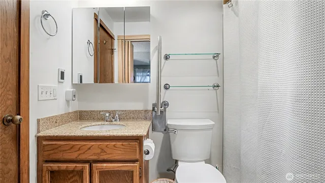 a bathroom with a granite countertop toilet and a sink