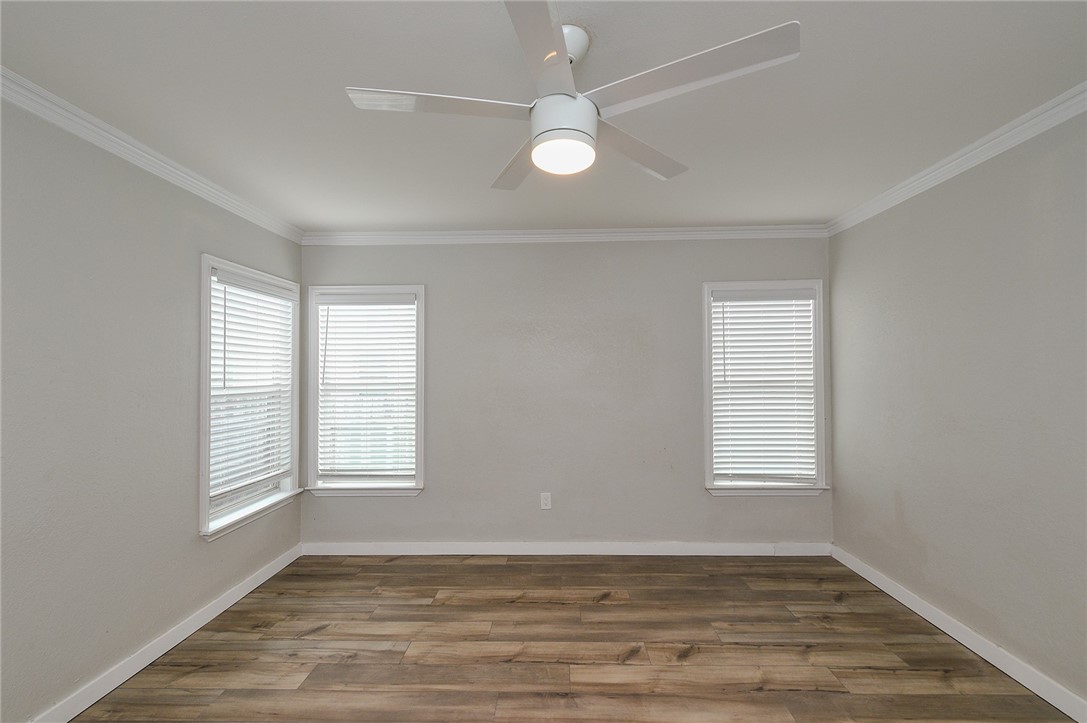 634 Mc Call Street Corpus Christi, TX 78404 - Photo 16 of 34 an empty room with wooden floor and windows