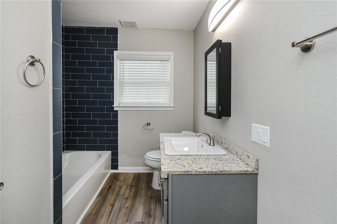 634 Mc Call Street Corpus Christi, TX 78404 - Photo 19 of 34 a bathroom with a granite countertop sink toilet and shower