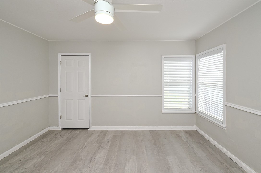 634 Mc Call Street Corpus Christi, TX 78404 - Photo 25 of 34 an empty room with wooden floor and windows