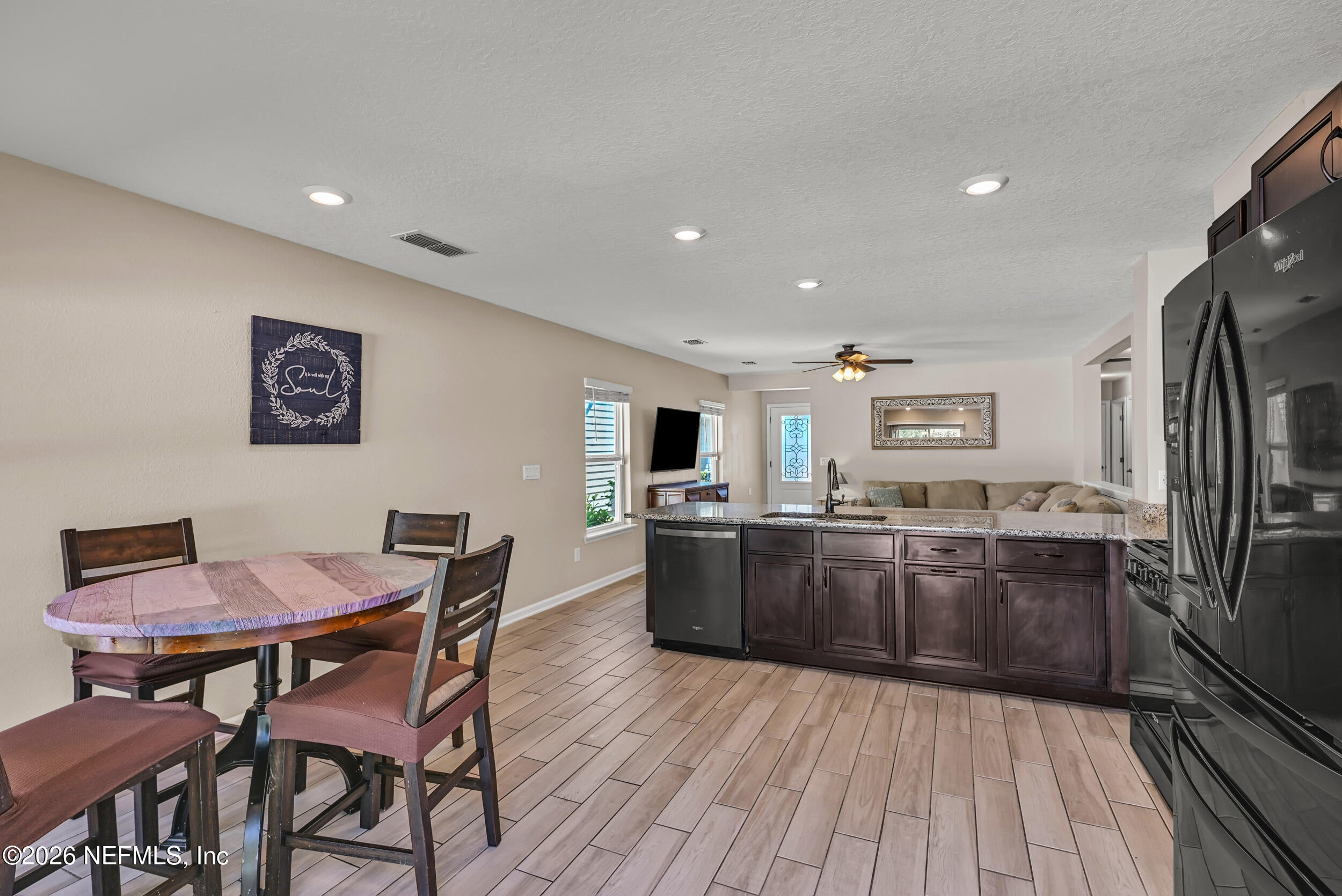 532 Bluejack Lane St. Augustine, FL 32095 - Photo 11 of 55 a kitchen with stainless steel appliances kitchen island granite countertop a table chairs and wooden floor