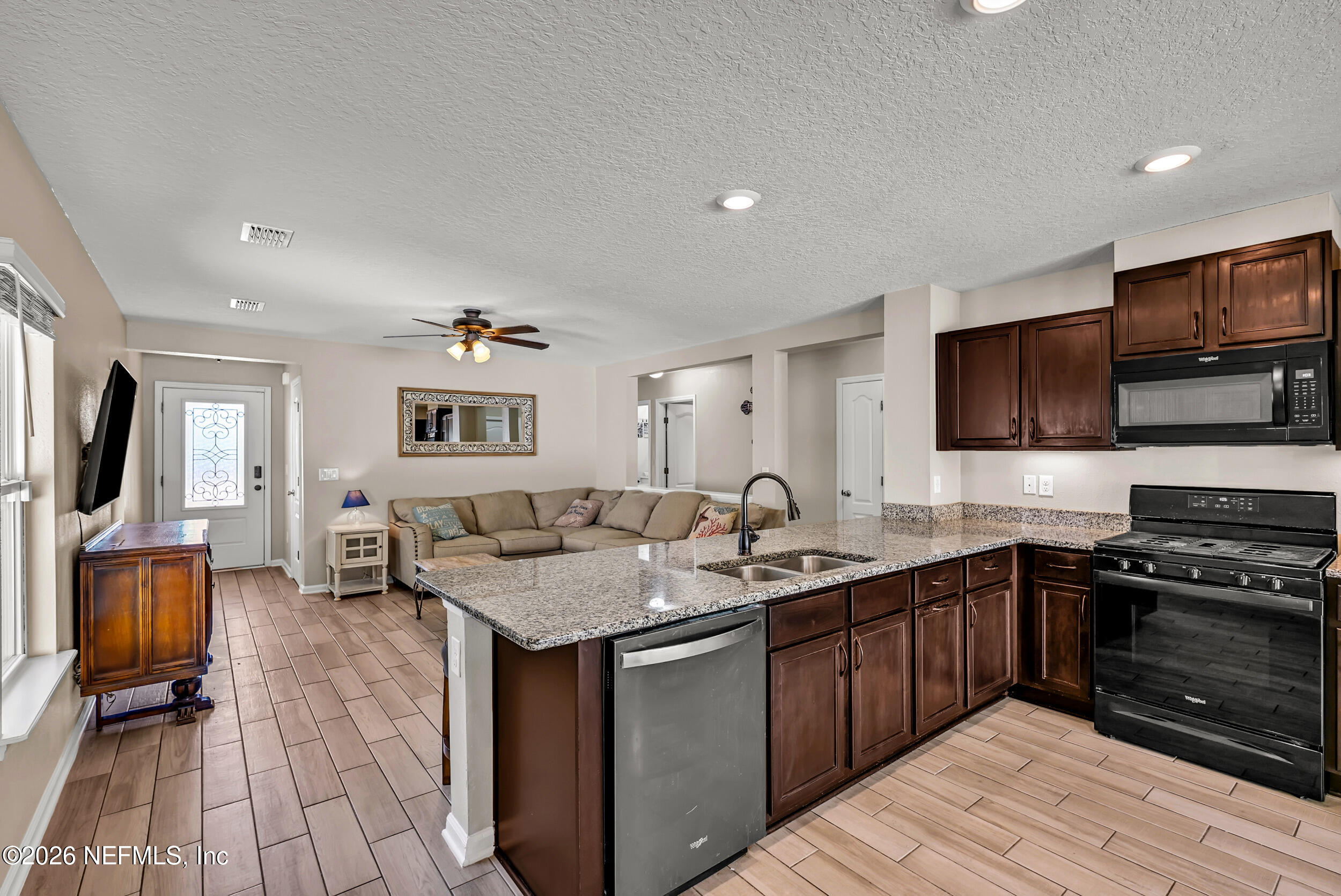 532 Bluejack Lane St. Augustine, FL 32095 - Photo 14 of 55 a open kitchen with stainless steel appliances granite countertop a sink dishwasher stove and oven with wooden floor